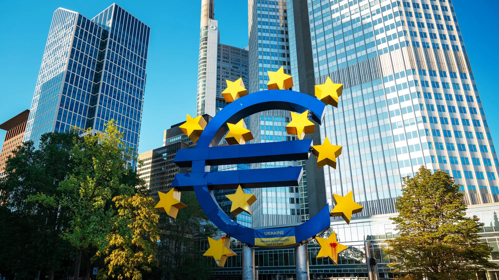 The photograph shows the iconic Euro symbol sculpture, adorned with stars, in front of the European Central Bank (ECB) headquarters, signifying discussions or developments regarding the digital euro.