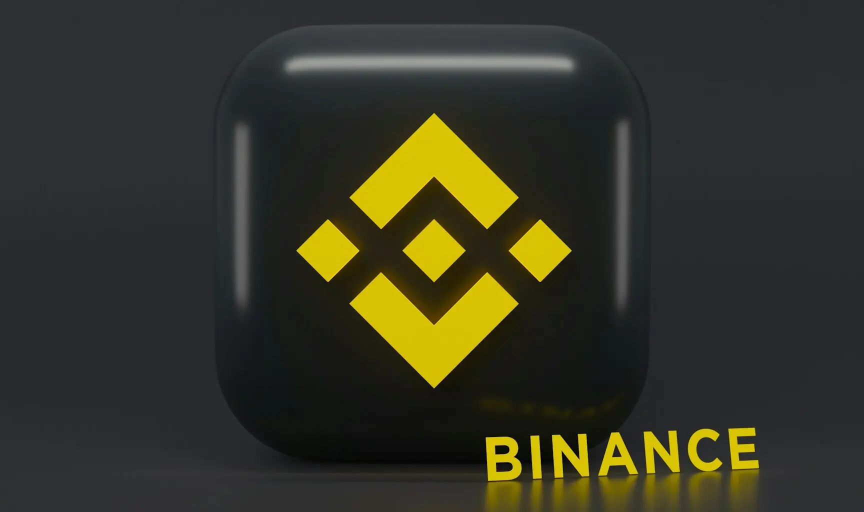 3D rendering of a black cube with the yellow Binance logo on it.