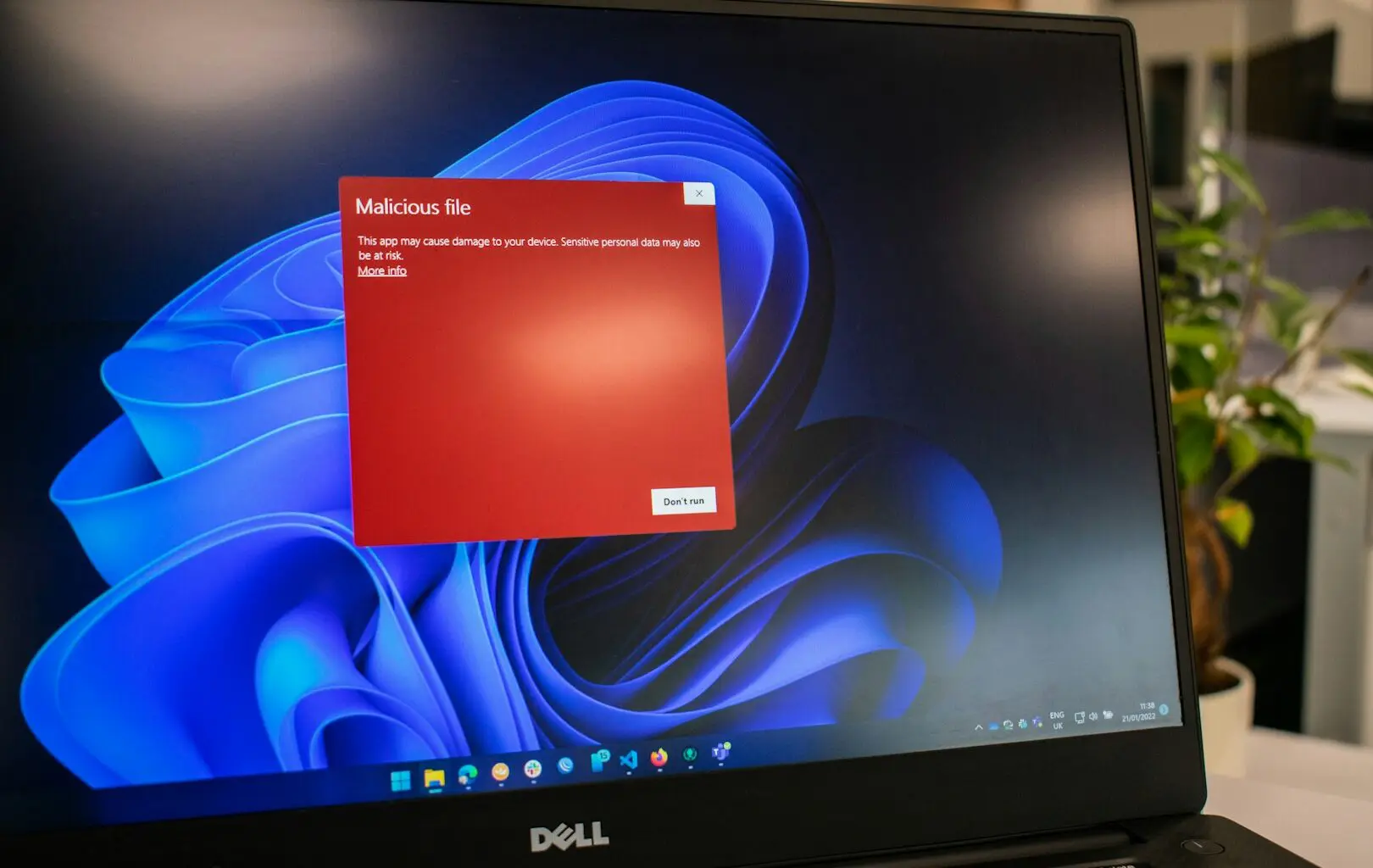 Red alert on a Dell laptop screen warns of a malicious file potentially linked to cryptojacking, highlighting the risk of device damage and data theft.