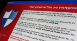 Computer screen displaying a red ransomware warning demanding payment to unlock encrypted files.