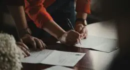 Multiple people signing a contract - representing fractional ownership.