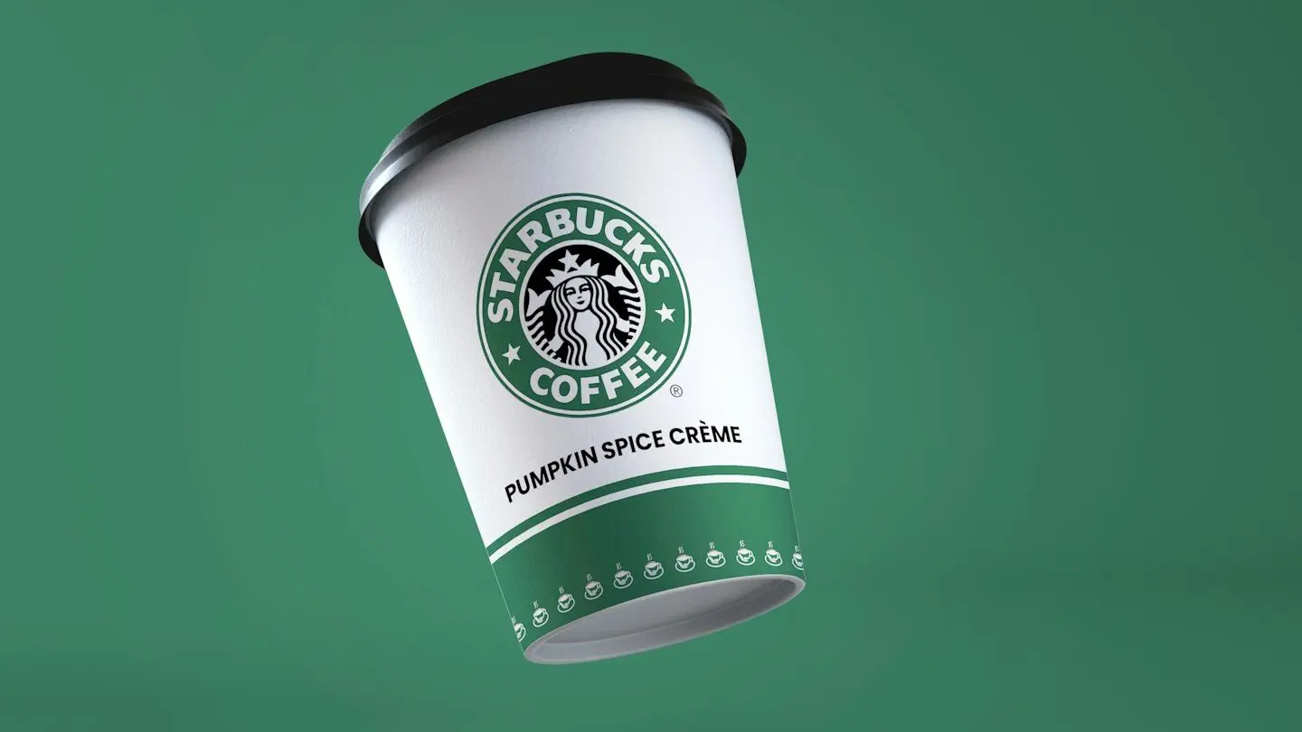 A Starbucks coffee cup labeled "Pumpkin Spice Crème" against a green background.







