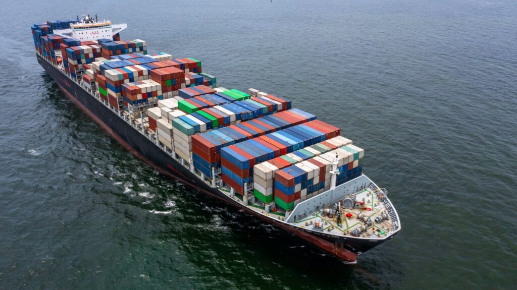 Cargo ship loaded with colorful containers at sea.