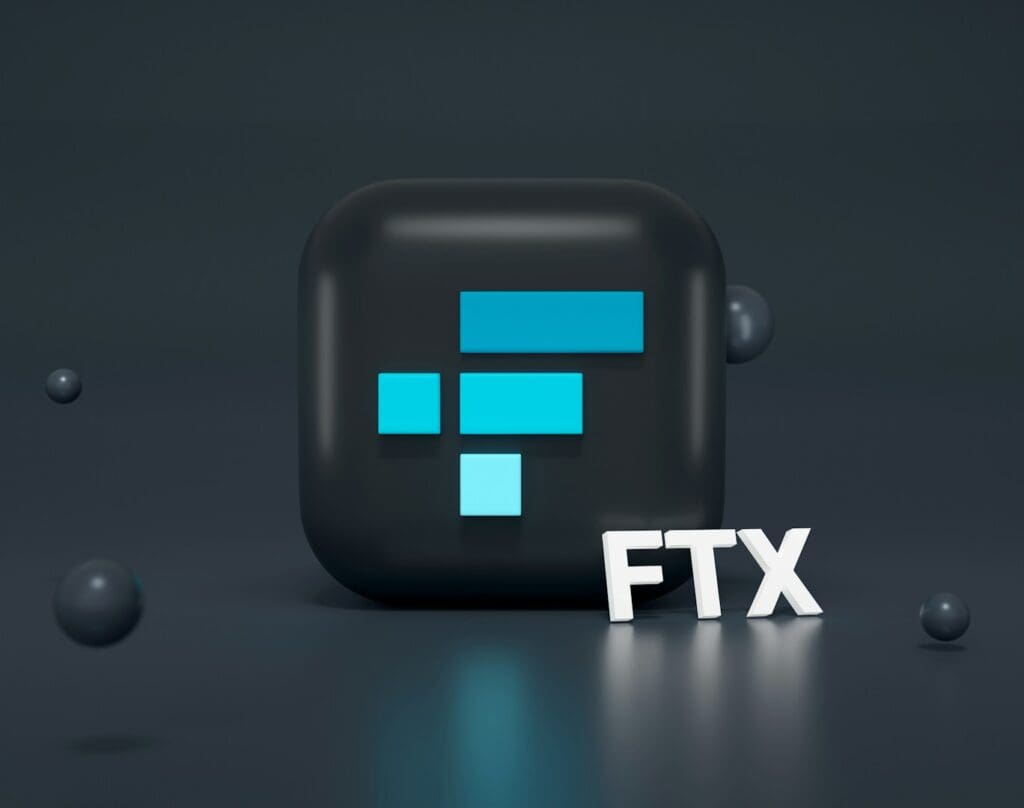 A logo of the FTX cryptocurrency exchange, known for its exit scam, featuring a 3D black cube with the blue FTX logo.
